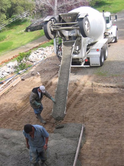 Construction crew pouring a concrete driveway from a ready mix concrete truck in Carmichael California