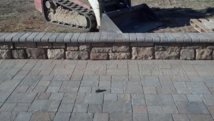 Small stone and concrete wall next to a stamped concrete patio that was installed